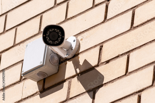 videcam mounted on a brick wall of a house on a summer day photo