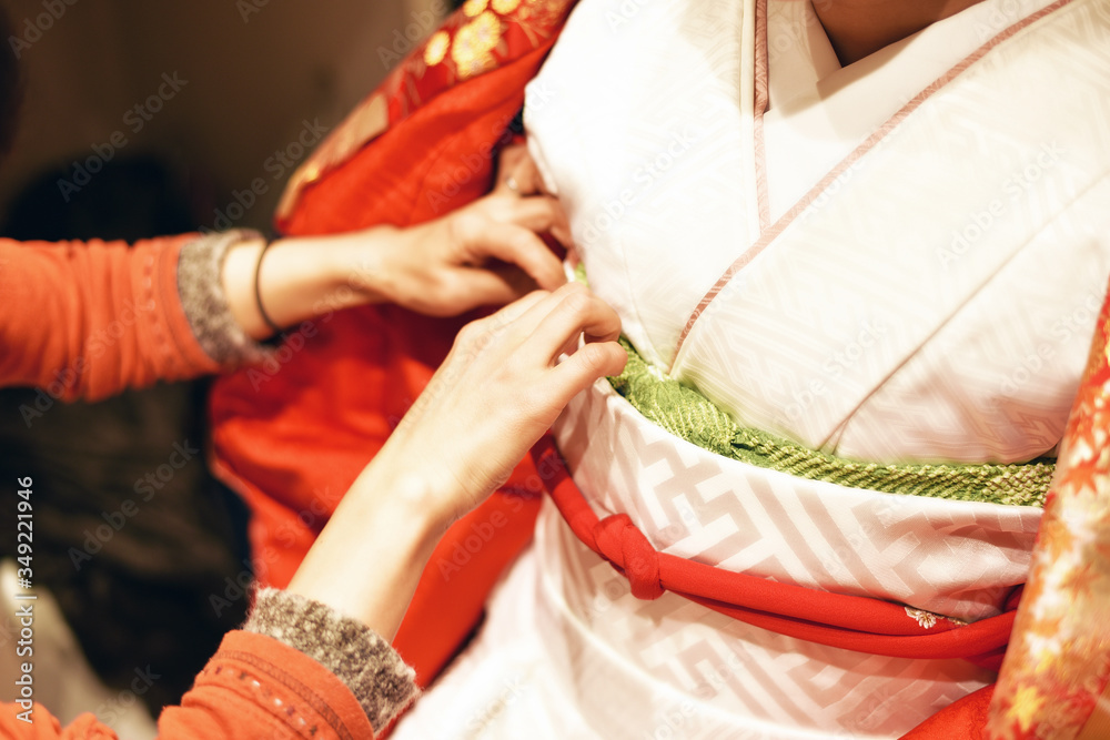A Japanese woman dressing a traditional wedding kimono.