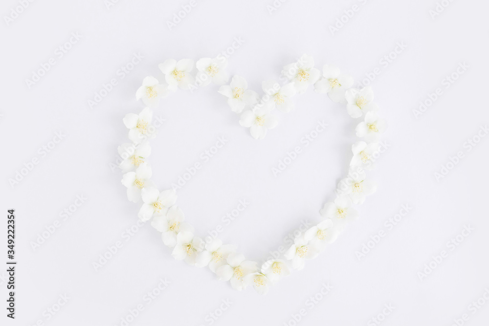 Flat lay in the shape of a heart from jasmine flowers on a white background. Flat lay in the shape of a heart from jasmine flowers on a white background.