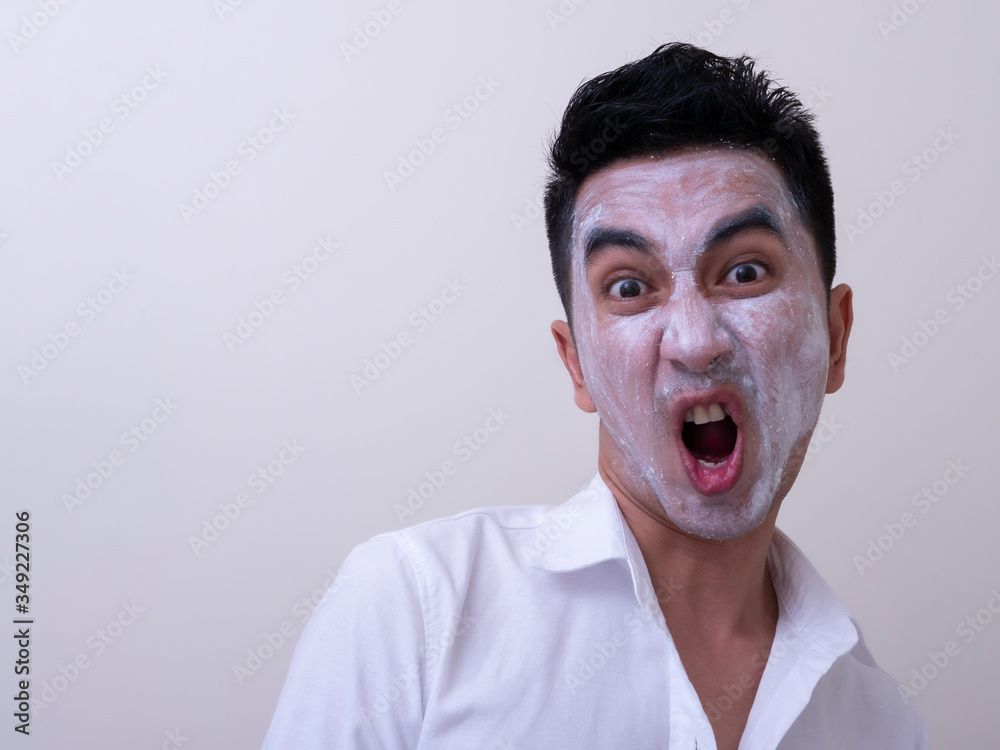 Asian handsome young man applying cream at his face with smiley face, Skin care concept Asian handsome young man applying cream at his face with smiley face, Skin care concept
