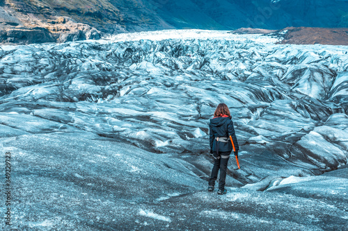 A young woman on her back with booties and hammer on the trekking of the Svinafellsjokull glacier. Iceland