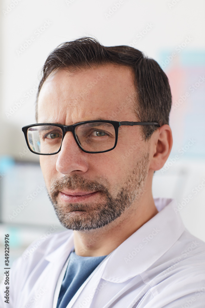 Close-up of mature male doctor in eyeglasses looking at camera while working at hospital Close-up of mature male doctor in eyeglasses looking at camera while working at hospital