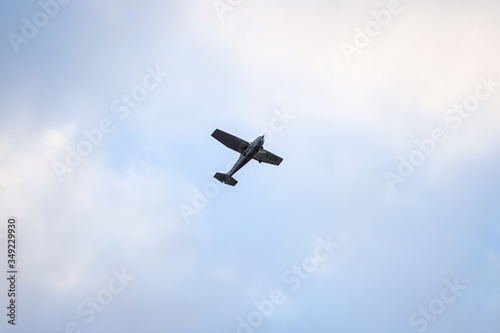 Small plane flying on the backgorund of clouds. Photo taken in cloudy day, Europe, Latvia.