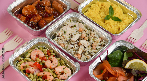 Healthy food  restaurant dish delivery. Take away of fitness meal. Weight loss nutrition in foil boxes. Top view on pink background. service food order online delivery. airline meals and snacks