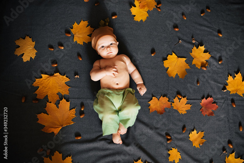 Newborn baby boy lies on autumn background