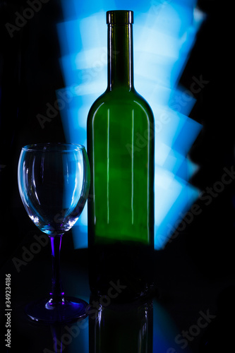 Crystal glass and a bottle of wine on a glass table