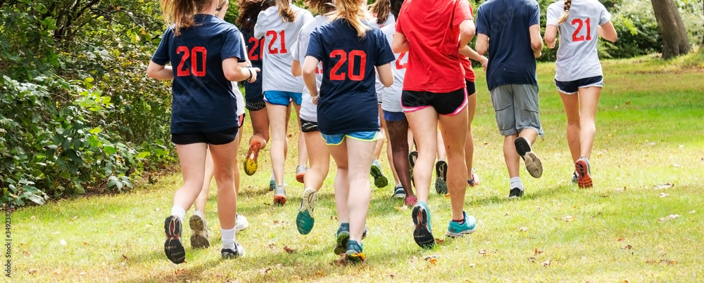 Group of runners training in a park on grass Group of runners training in a park on grass