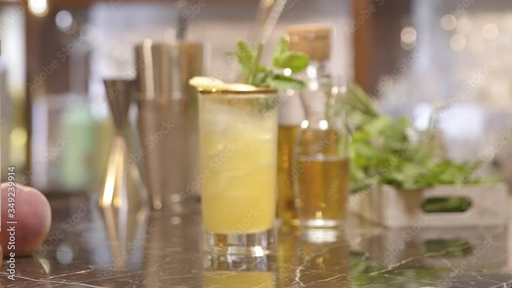 a drink with peaches on the table and rosemary - rack focus a drink with peaches on the table and rosemary - rack focus