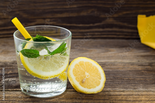Lemonade or mojito cocktail with lemon and mint with ice. Cold summer refreshing drink decorated with yellow napkin