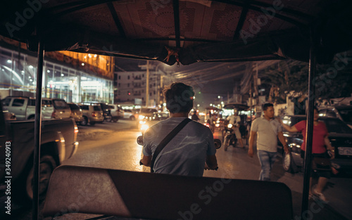 Photography tuk-tuk rides through a night city in Cambodia in the headlights