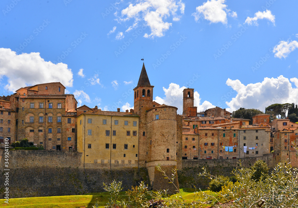 Fototapeta premium landscape with Anghiari italian medieval village city walls on green hill and blue sky in background. Arezzo, Tuscany Italy Europe.