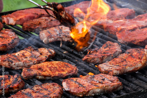 Steaks werden auf einem großen Holzkohle-Grill gegart.