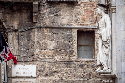 Statue of Saint Peter by Vecchietta. Statues decorating facade of Loggia della mercanzia in Siena, Tuscany, Italy photo