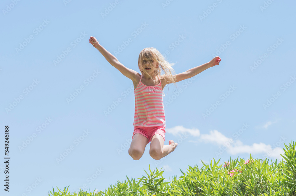 Happy crazy kid jumping on a trampoline, Summertime fun Happy crazy kid jumping on a trampoline, Summertime fun
