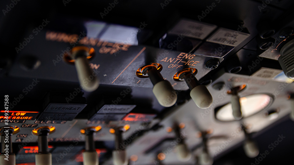Close detailed view on the cockpit of a large transport commercial jet airplane. Selective focus close up on the overhead panel with anti icing equipment and hydraulic pumps switches Close detailed view on the cockpit of a large transport commercial jet airplane. Selective focus close up on the overhead panel with anti icing equipment and hydraulic pumps switches