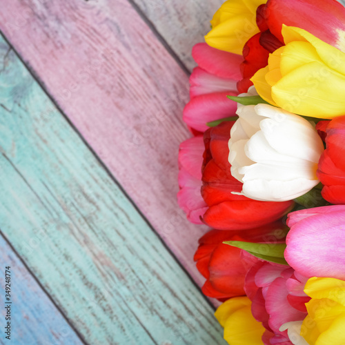 Fototapeta Naklejka Na Ścianę i Meble -  A bouquet of fresh, bright, multi-colored tulips on wooden planks.
