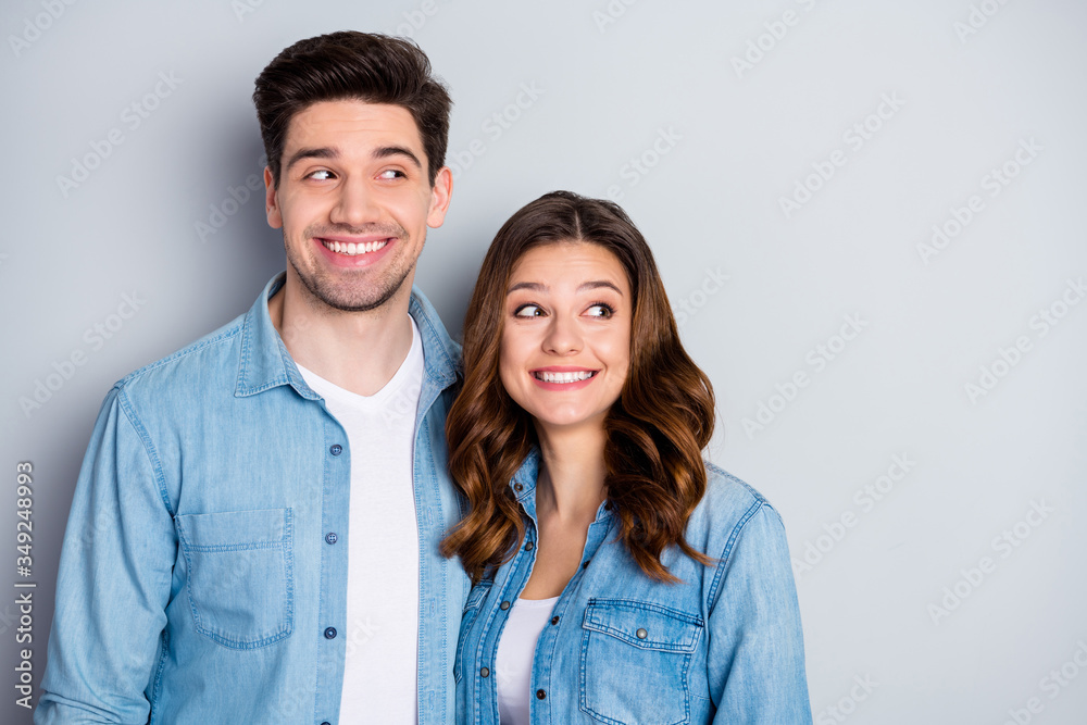 Photo two funny beautiful people lady guy stand side by side look tricky side empty space chatterbox childish mood wear casual denim shirts outfit clothes isolated grey color background Photo two funny beautiful people lady guy stand side by side look tricky side empty space chatterbox childish mood wear casual denim shirts outfit clothes isolated grey color background