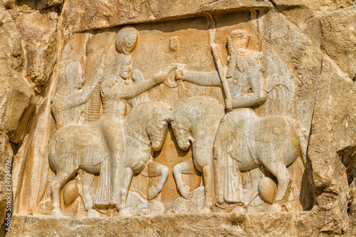 Ancient relief of the necropolis Naqsh-e Rustam that shows the triumph of Shapur I over the Roman Emperor Valerian and Philip the Arab, near ruins of Persepolis. Middle East, Asia photo