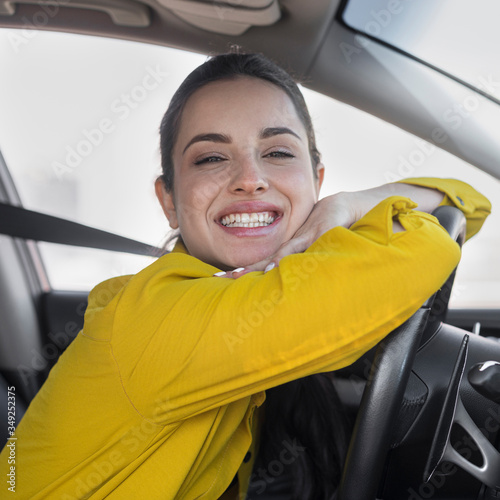 Smiling woman leaning on the steering wheel
