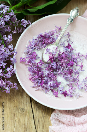 Lilac flowers with sugar  lilac and pink napkin on a wooden background. Rustic style.