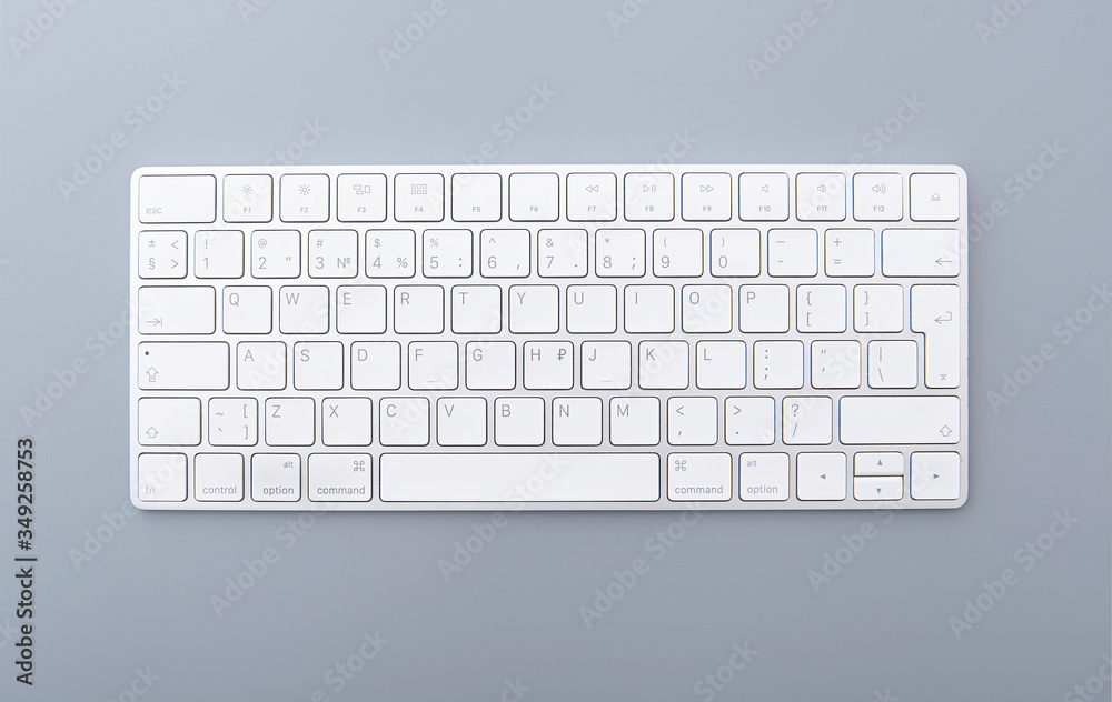 Close-up white keyboard on gray desk, top view of modern computer keyboard isolated on gray background 