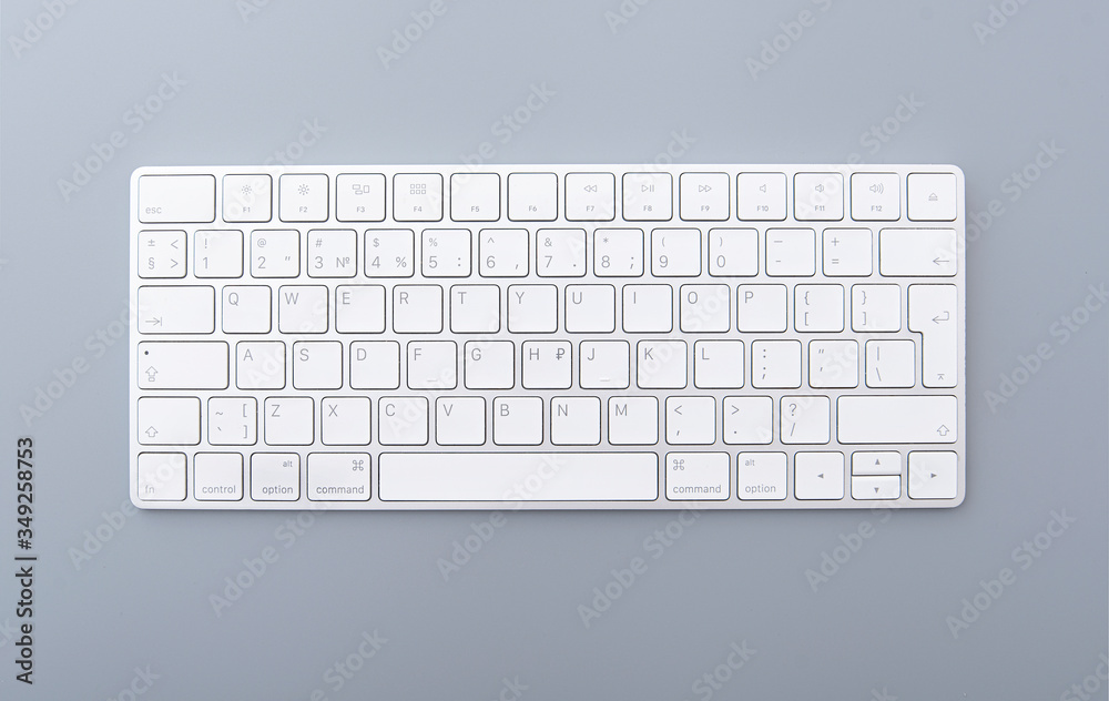 Close-up white keyboard on gray desk, top view of modern computer keyboard isolated on gray background Close-up white keyboard on gray desk, top view of modern computer keyboard isolated on gray background