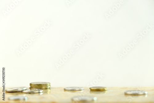 background image. Stacks of gold and silver coins on a light brown background