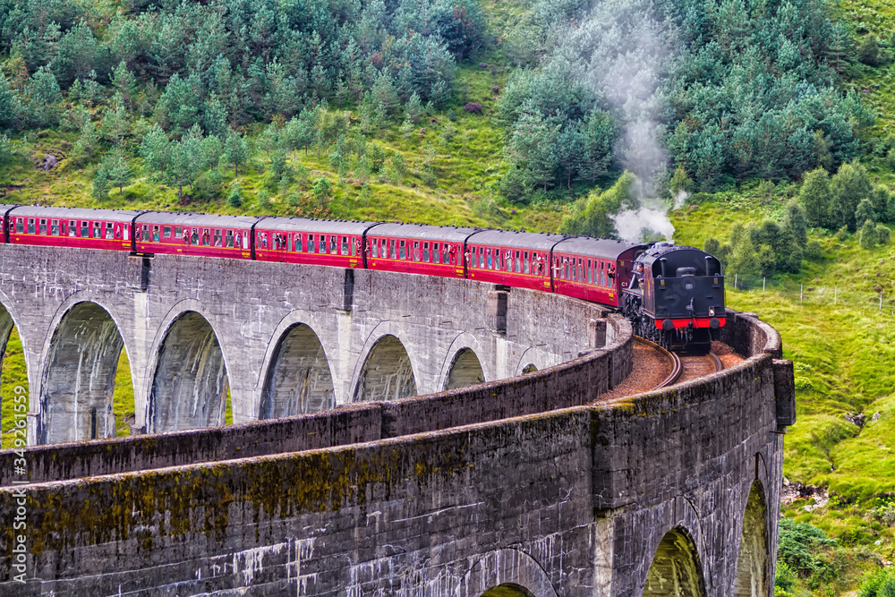 Naklejka premium Glenfinnan Railway Viaduct in Scotland with the Jacobite steam train passing over. United Kingdom
