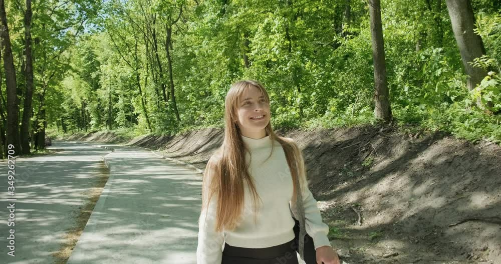 Young girl goes for yoga training in nature calm mood. Woman relaxes in a city nature park. Slow motion Young girl goes for yoga training in nature calm mood. Woman relaxes in a city nature park. Slow motion