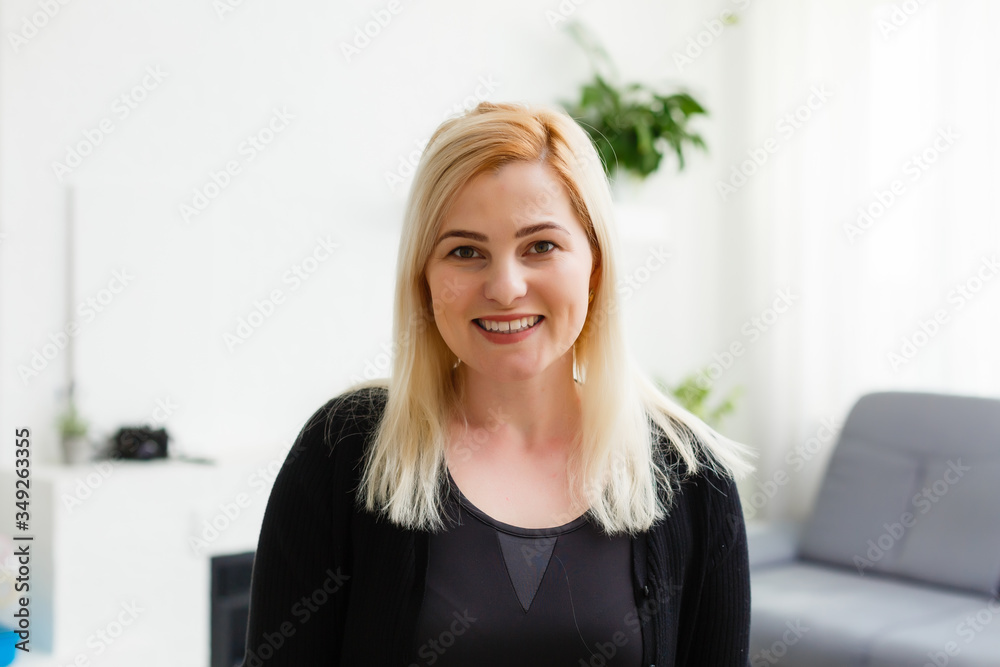 Portrait happy smiling young woman waving hand in the kitchen, looking at camera, greeting, saying hello, head shot portrait Portrait happy smiling young woman waving hand in the kitchen, looking at camera, greeting, saying hello, head shot portrait