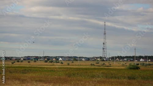 Village peyzad, modern village with cellular communications tower in middle, Russia, outback, summer, high clouds in sky, field, ecology, day tends to decline, general plan of village, countryside photo