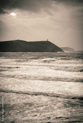 Storm over sea, headland, waves and swell, black and white vintage. Stepper point from Polzeath, Cornwall