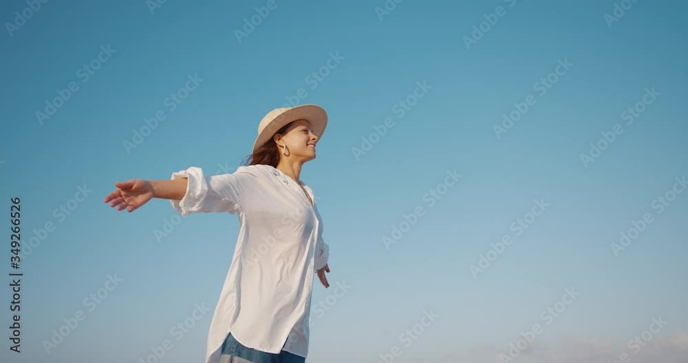 Happy young girl on a background of blue sky. Shot on Black Magic Cinema Camera Happy young girl on a background of blue sky. Shot on Black Magic Cinema Camera