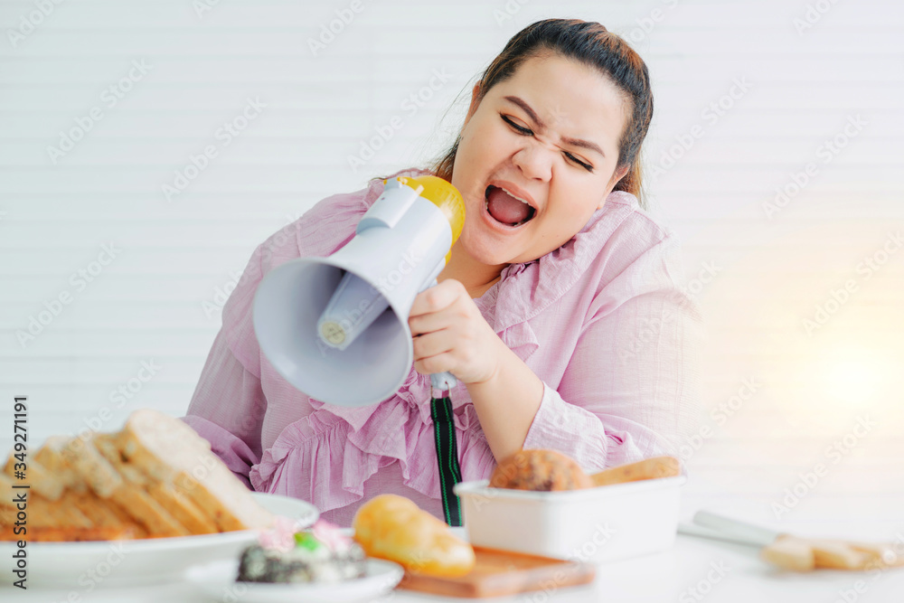 Fat woman feels angry the unhealthy food placed in front of her makes her fat, fat woman holding a megaphone and shouting Fat woman feels angry the unhealthy food placed in front of her makes her fat, fat woman holding a megaphone and shouting