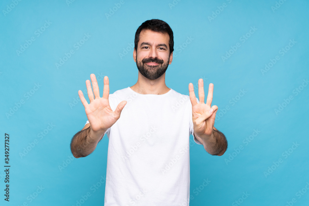 Young man with beard over isolated blue background counting eight with fingers Young man with beard over isolated blue background counting eight with fingers