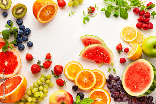 Assorted fresh fruits and berries on white background. Clean eating, healthy life. Top view.