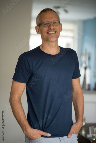 Portrait of caucasian middle aged man with blue shirt at home.