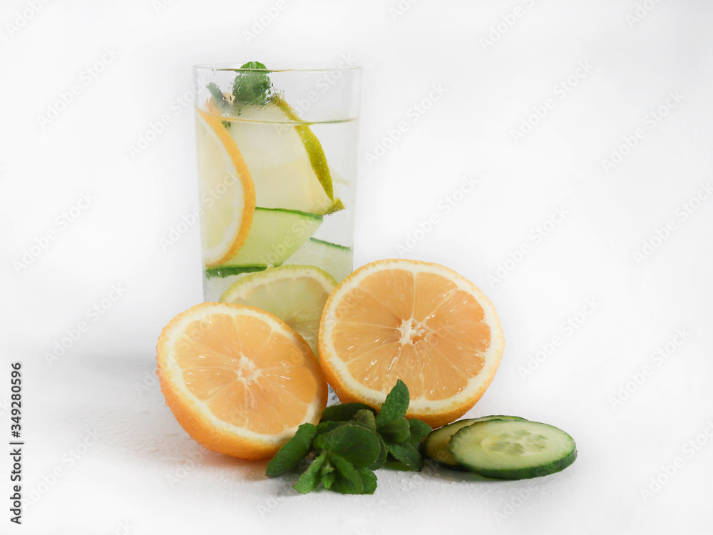 Fototapeta premium Chilled summer cocktail lemonade in a glass cup with ice, lemon, fresh cucumber and mint leaves. homemade lemonade to quench your thirst in the heat. selective focus.