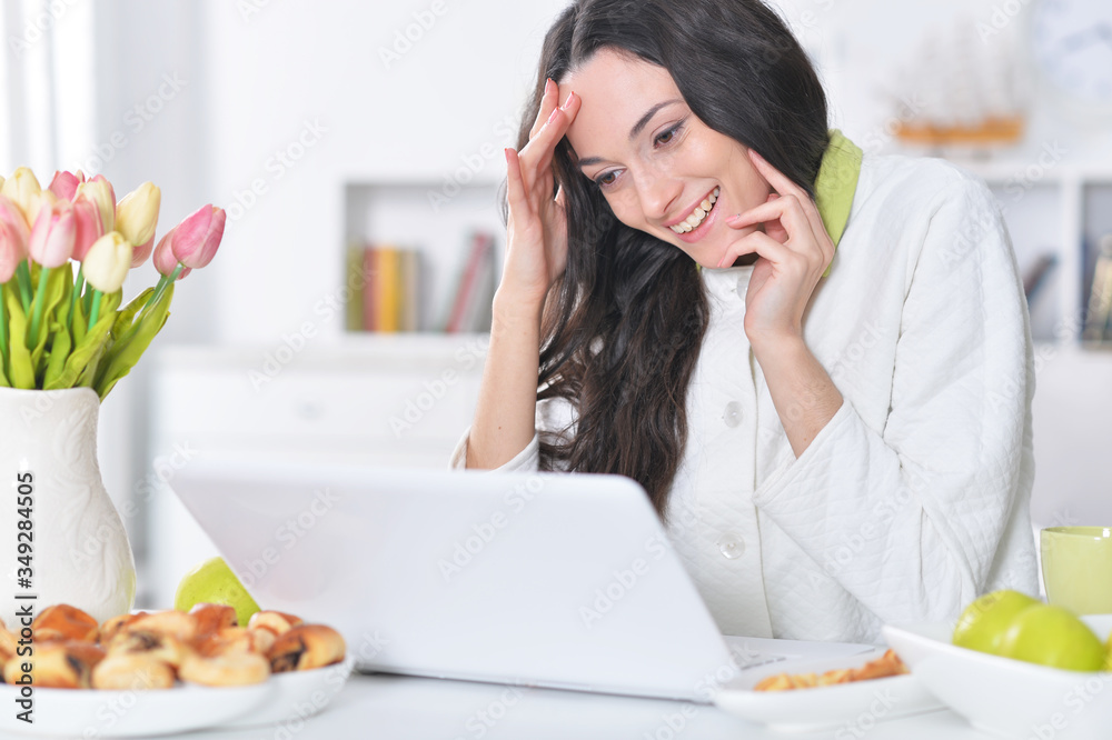 Beautiful young woman using laptop at table at home Beautiful young woman using laptop at table at home