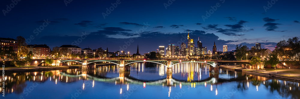 Illuminated Cityscape of Frankfurt am Main, Germany at Night with Reflective Bridge