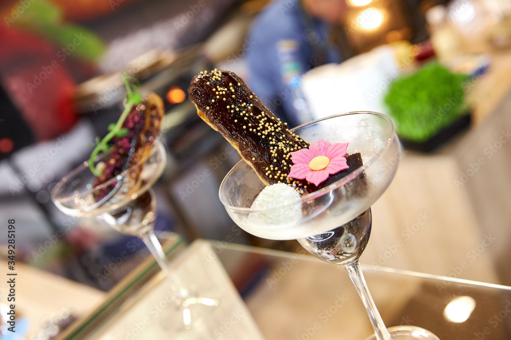 chocolate eclair in a champagne glass decorated with a flower of sweet mastic