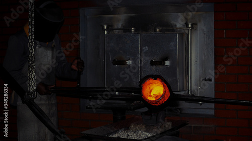 Fotografie pouring a crucible of  molten metal fresh from a hot furnace