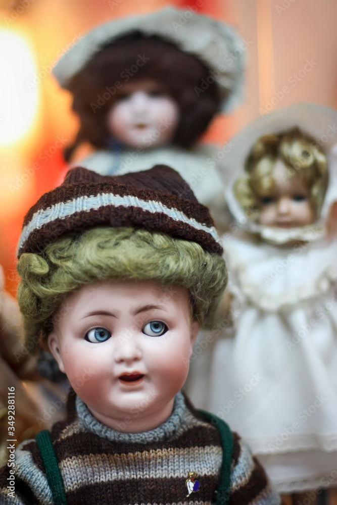Três bonecos de porcelana muito antigos, com nitidez no primeiro boneco e os demais desfocados.