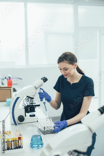 Smiling young female working with liquids in the laboratory