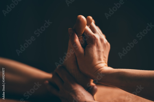 Professional foot massage close up. Authentic shot of luxury spa treatment. Charming light. Shallow depth of field. Stylized and colored. Copy space