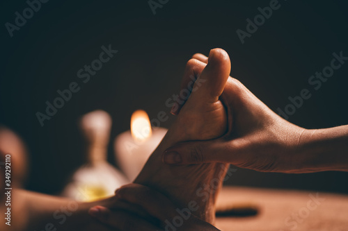 Professional foot massage close up. Authentic shot of luxury spa treatment. Charming light. Shallow depth of field. Stylized and colored. Copy space