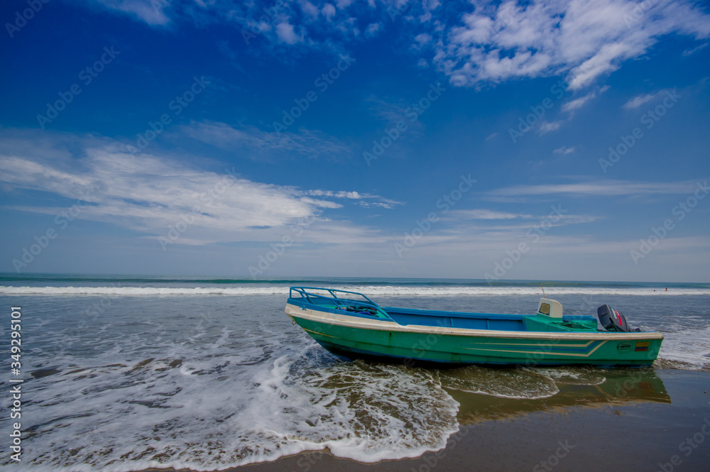 SAME, ECUADOR - MAY 06 2016: Fishing boat on the beach in the sand in a beautiful day in with sunny weather, blue sky in Same, Ecuador