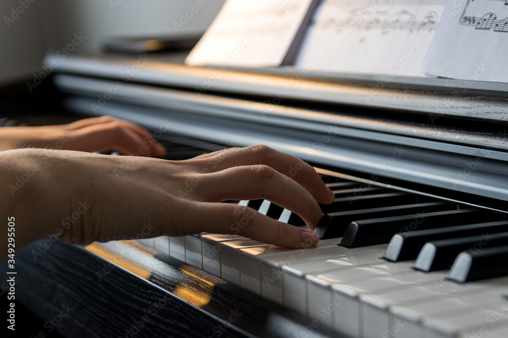 Obraz premium Young girl playing digital piano...