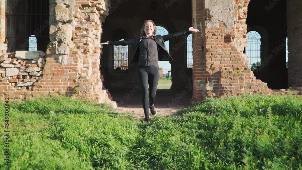 Happy girl running towards the exit with his hands raised up. Freedom. Slow motion. Shooting on the Steadicam Happy girl running towards the exit with his hands raised up. Freedom. Slow motion. Shooting on the Steadicam