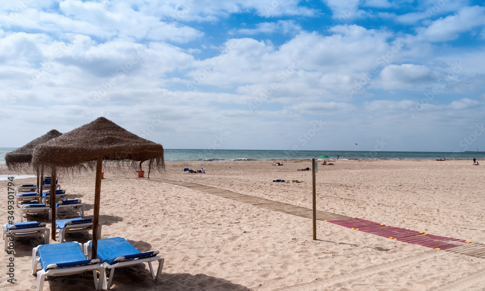 Sun loungers and parasols prepared on the beach of Cadiz, Spain Sun loungers and parasols prepared on the beach of Cadiz, Spain